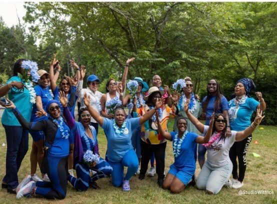 LESANs in blue cheering together outdoors